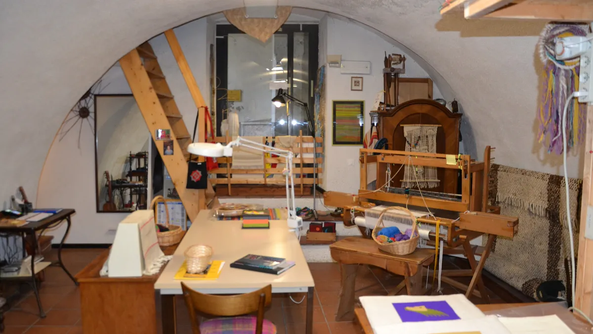 L'interno del laboratorio: il telaio, il tavolo di lavoro e la volta della sede di via Portici